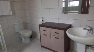 a white bathroom with a sink and a toilet at Sintha guest house in Kraaifontein +7 photos