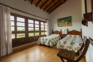 ein Schlafzimmer mit zwei Betten und einem Fenster in der Unterkunft Casas Rurales Playa de Guadamía in Llames de Pría