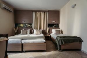 a hotel room with two beds and a window at Planos Beach Hotel in Tsilivi +57 photos