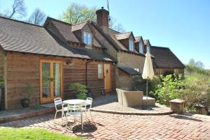a house with a table and chairs and an umbrella at The Hen Den in Ludlow
