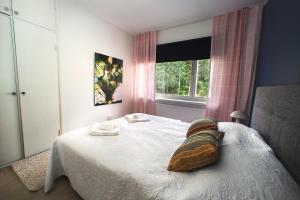 a bedroom with a white bed with a window at Saimaa Design, lake view, AC, Wifi in Savonlinna