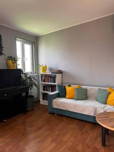 a living room with a couch and a piano at Evergreen Hostel Metrostroevskaya in Almaty
