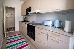 a kitchen with white cabinets and a colorful rug at Saimaa Design, lake view, AC, Wifi in Savonlinna +17 photos