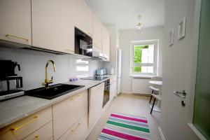 a kitchen with white cabinets and a sink and a window at Saimaa Design, lake view, AC, Wifi in Savonlinna