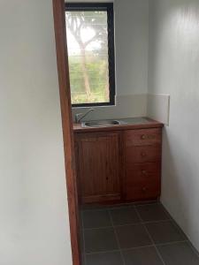 a bathroom with a sink and a window at Helt Vanua Lodge in Saraotou