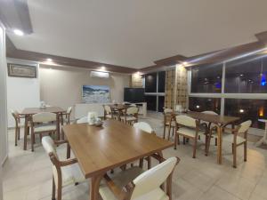 a restaurant with wooden tables and chairs and windows at Samsun Park Hotel in Samsun