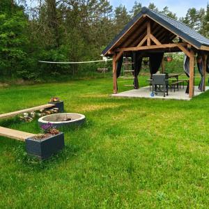 a gazebo with a fire pit in a yard at Pokoje Agnieszka in Pollnow