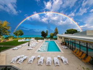 a rainbow over the pool at a resort with lounge chairs at Skyline 11B Apartment - Sea View,Pools & SPA in Varna City