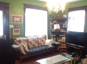 ein Wohnzimmer mit einem Sofa und einem TV in der Unterkunft Maison McKenzie House in Campbellton