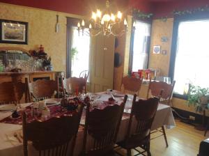 a dining room with a table and chairs and a chandelier at Maison McKenzie House in Campbellton
