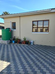 a house with a brick patio in front of it at Sintha guest house in Kraaifontein