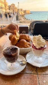 a table with two plates of pastries and two bowls of food at Ursino inn camere e suite in Catania