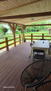 a patio with a table and chairs on a deck at Mazurski Zakątek in Ławki