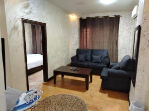 a living room with a blue couch and a table at Siveen Hotel in Amman