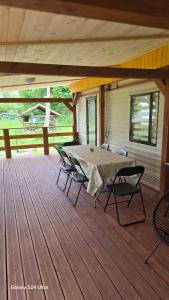 a patio with a table and chairs on a deck at Mazurski Zakątek in Ławki
