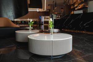 two white tables with flowers on top of a counter at Serbellas Boutique Hotel in Paphos