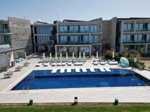 an outdoor swimming pool with chairs and a building at Serbellas Boutique Hotel in Paphos