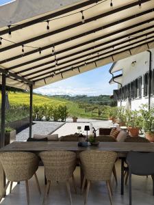 an outdoor patio with a wooden table and chairs at Casa Alba Blu in Dogliani