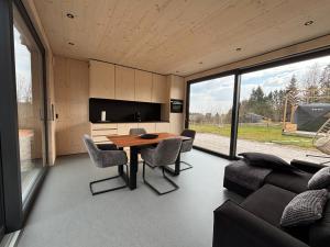 a living room with a wooden table and chairs at Chalet WaldZeit in Weiskirchen