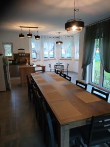 a dining room with a large wooden table and chairs at Pokoje Agnieszka in Pollnow