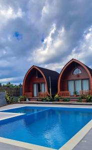a house with a swimming pool in front of it at Bale Rinjani Lodge & Cafe in Tetebatu