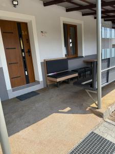 eine Veranda mit einer Bank und einer Holztür in der Unterkunft Hostel 405 in Polanka Wielka