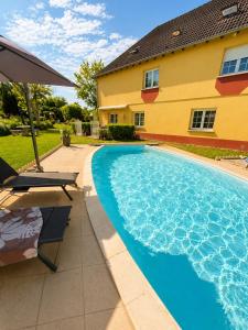 a swimming pool in front of a house at 185 m duplex with pool near Strasbourg in Ittenheim