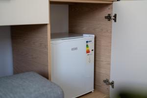 a small refrigerator in a room with a wooden wall at Rexha Apartments in Ulcinj +15 photos