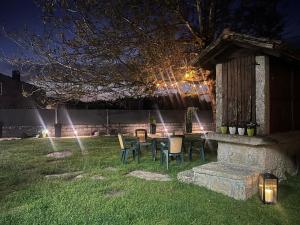 a table and chairs in a yard at night at Casa soengas in Monterroso