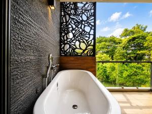 a bath tub in a bathroom with a window at Reiz - Private Residence in Chiang Mai +63 photos