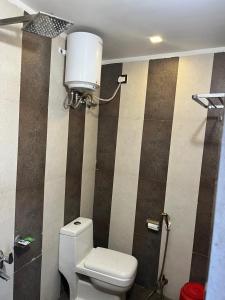 a bathroom with a toilet and a water tank at Hotel V Square in Lucknow +5 photos