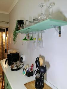 a kitchen counter with a blue shelf on the wall at 47atKabega in Gqeberha +29 photos