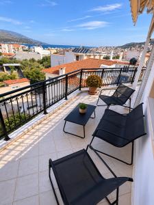 a balcony with chairs and a table and a view at Théa Loft Premium Sunset Sea View Escape in Vathý