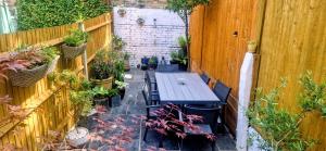a patio with a table and some potted plants at Double Bed at Cozy Hailsham in London