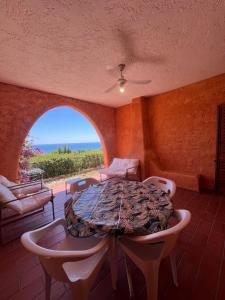 a room with a table and chairs and a view of the ocean at APPARTAMENTI BIANCANEVE by VILLA AUREA CAV in Costa Rei