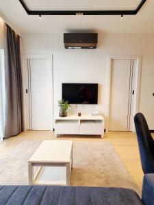 a living room with a couch and a tv at Apartament Ryżowa 66B in Warsaw +2 photos