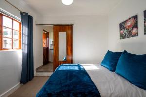 a bedroom with a bed with blue pillows at St Rand Holiday House in Strand +4 photos