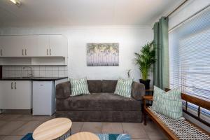 a living room with a couch and a kitchen at St Rand Holiday House in Strand