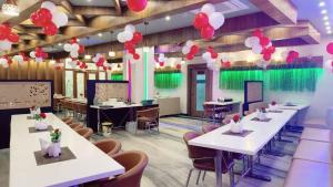 a dining room with tables and red and white balloons at Hotel V Square in Lucknow