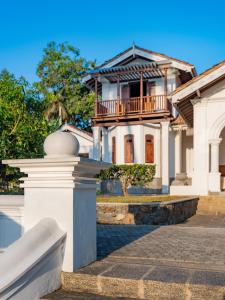 a white house with a balcony on top of it at The Colonial Escape in Galle