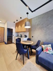 a living room with a table and a blue couch at Apartament Ryżowa 66B in Warsaw