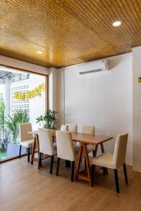 a dining room with a wooden table and chairs at Haonorn Hostel in Thong Sala