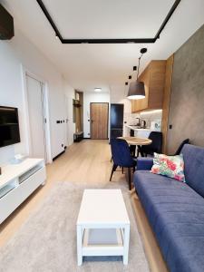 a living room with a blue couch and a table at Apartament Ryżowa 66B in Warsaw