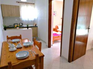 a kitchen and a dining room with a wooden table at Nikos Apartments 2 in Kavos