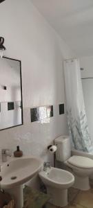 a white bathroom with a toilet and a sink at El Molino de Iramala in Reolid