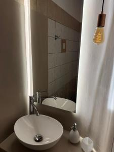 a bathroom with a sink and a mirror and a tub at PANORAMIO in Batsi +7 photos