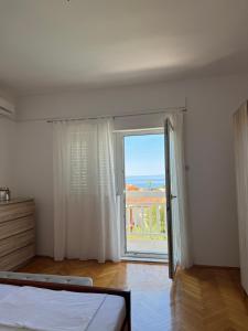 a white room with a large window and a bed at Hugo in Promajna