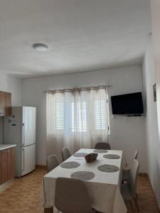 a dining room with a table and a refrigerator at Hugo in Promajna
