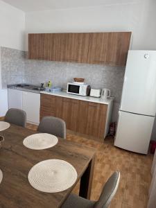 a kitchen with a table and a white refrigerator at Hugo in Promajna