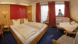 a hotel room with a large bed and a table at Hotel Gasthof Rose in Oy-Mittelberg